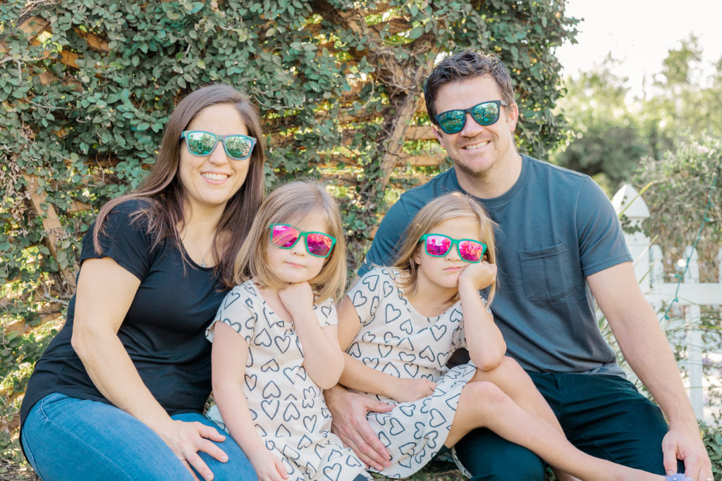 family of 4 smiling with sunglasses on at rockledge gardens