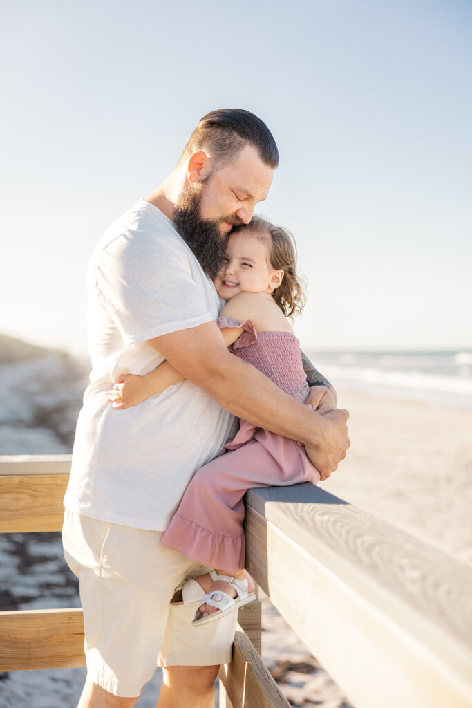 dad hugs his daughter on playalinda beach near Titusville, Florida