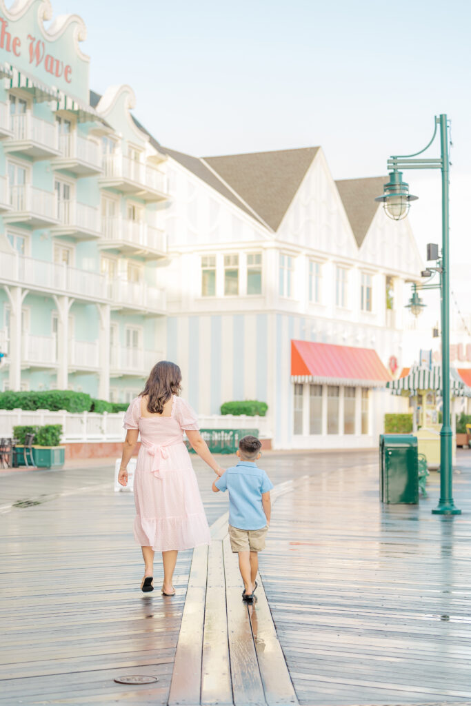 mother and son walking down boardwalk at Disney