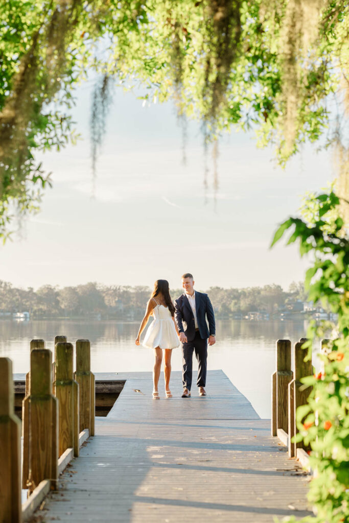 Engaged couple walking in front of the Spanish‑Mediterranean Knowles Memorial Chapel at Rollins College in Winter Park