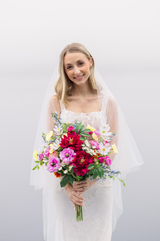 Couple embracing on the white‑sand beach at Rollins College with a Lake Virginia sunset as the backdrop