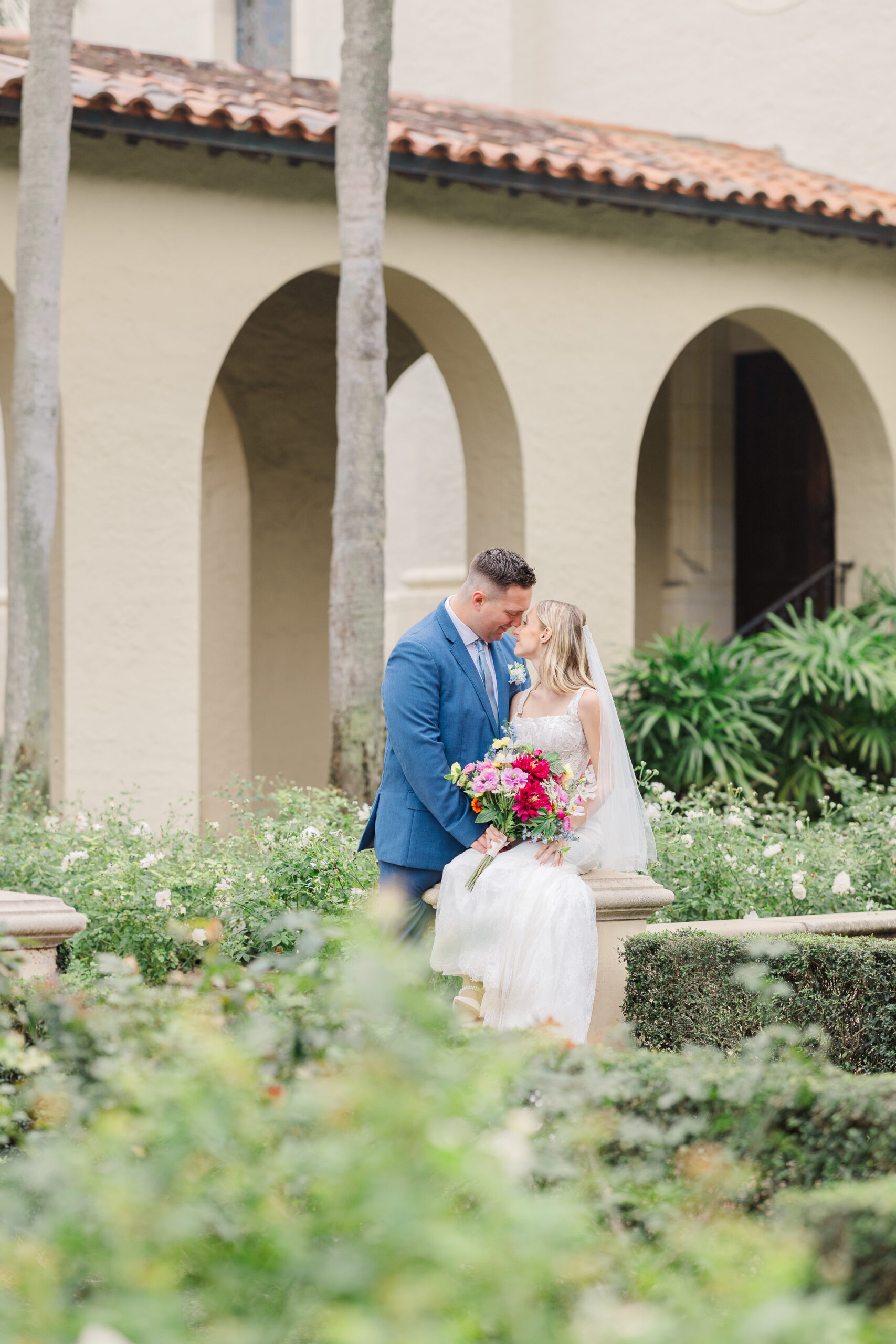 Couple embracing on the white‑sand beach at Rollins College with a Lake Virginia sunset as the backdrop