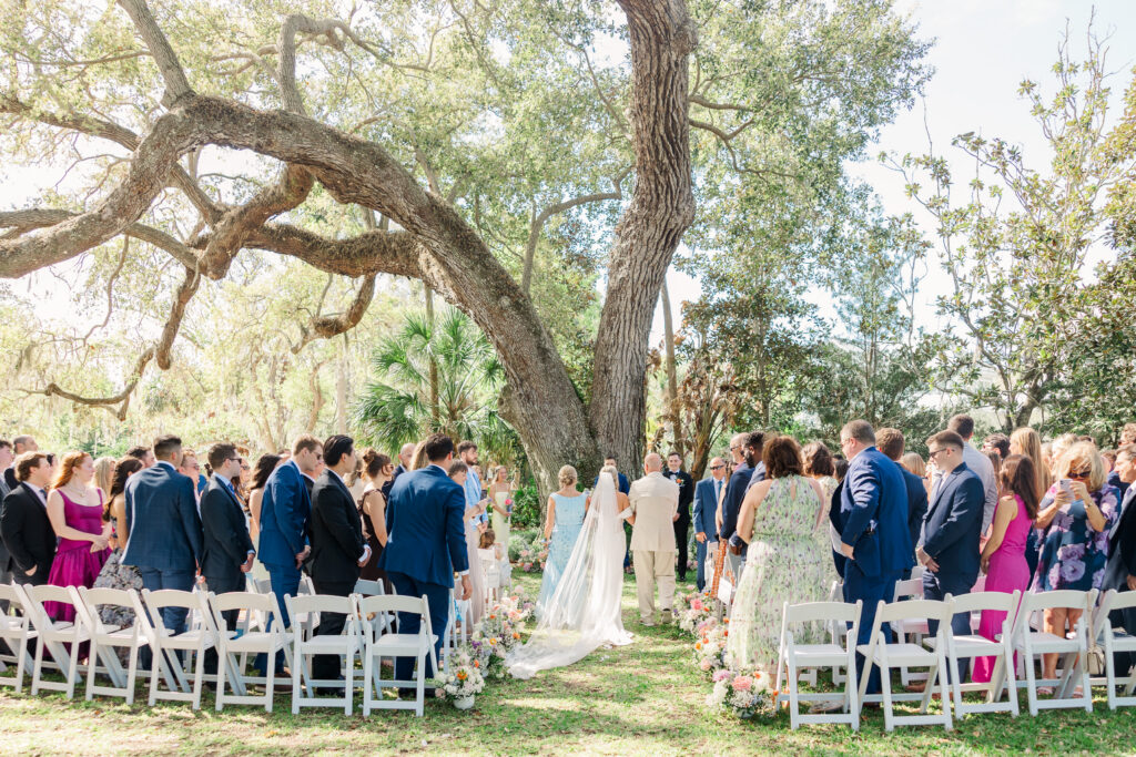 Bride walking down aisle with parents emotional moment