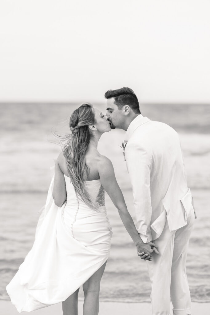 bride and groom kiss on beach