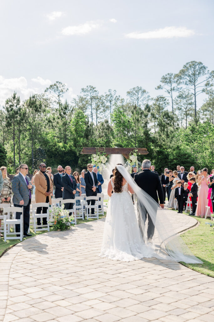 bride walks down the aisle with her father.